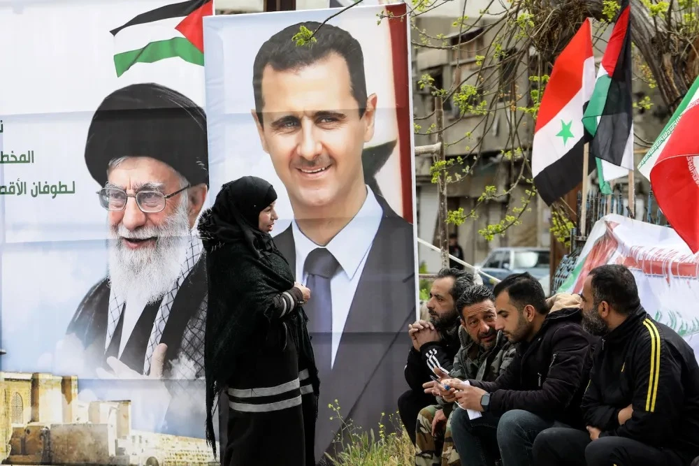 Chân dung của Lãnh tụ Tối cao Iran Ali Khamenei (trái) và Tổng thống Syria Bashar al-Assad tại thủ đô Damascus (Syria) hồi tháng 3. Ảnh: AFP