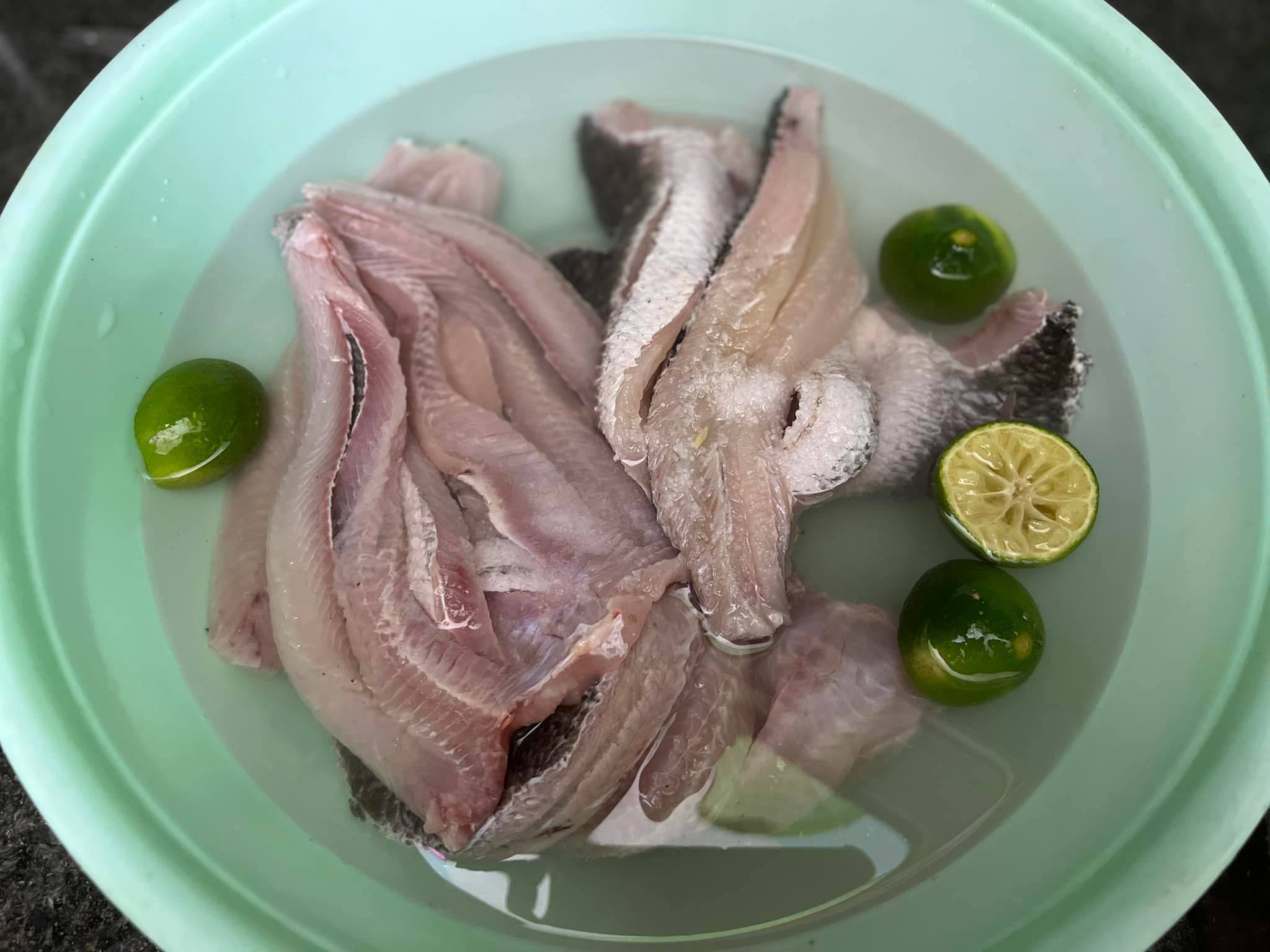 Cho cá vào chậu nước có pha nước chanh và muối hạt. Dùng bàn chải chà sạch phần nhày trên thân và trong mình cá. Sau đó rửa sạch bằng nước và để ráo.