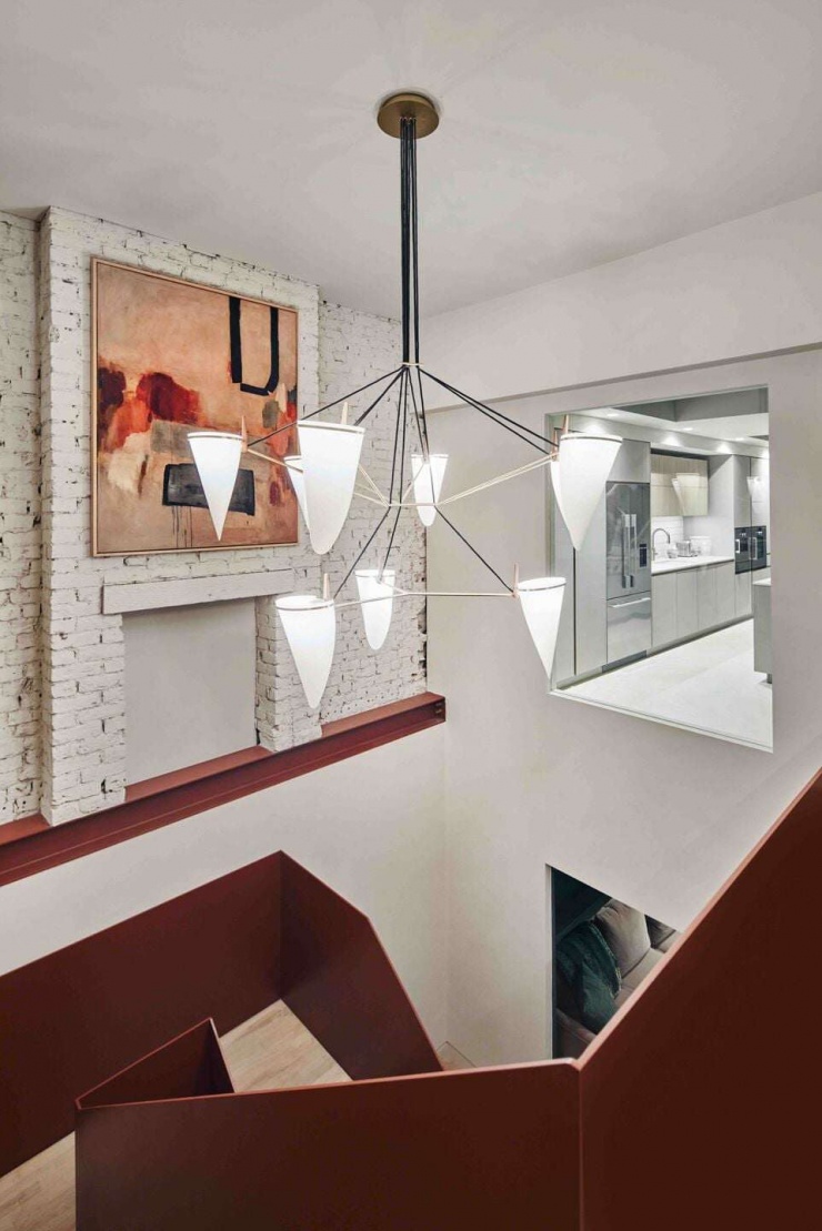 Khu vực thông tầng kết hợp đèn trang trí treo thả tạo chiều sâu và cảm giác kết nối giữa các tầng. Giải pháp này không chỉ cải thiện ánh sáng mà còn mang lại trải nghiệm không gian sinh động khi di chuyển trong nhà